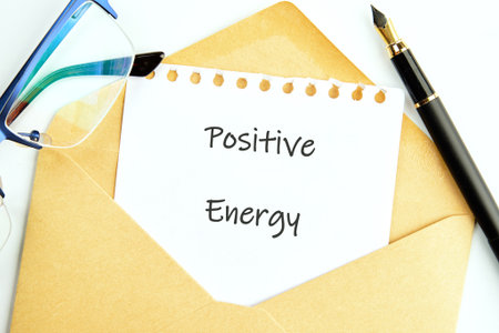 In a bright workspace, a handwritten note reading Positive Energy peeks out of a simple envelope....