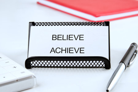 Motivational phrases are displayed prominently on a desktop, surrounded by study materials and a sleek pen, signaling ambition and dedication to achieving goals.の写真素材