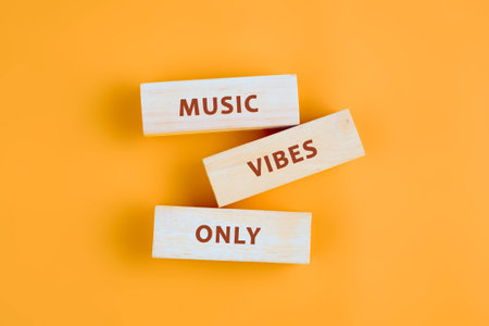 Colorful wood blocks display the phrase music vibes only against a bright yellow backdrop, creating a cheerful mood perfect for any music lover or celebration.の写真素材