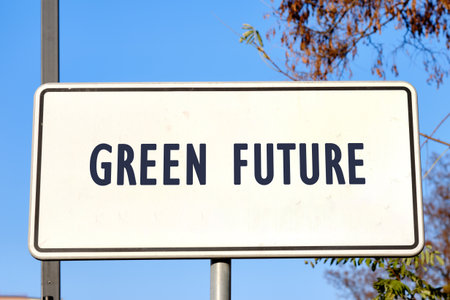 A sign displays the words Green Future, symbolizing a positive vision for the environment. The backdrop features a bright blue sky and hints of nature, evoking tranquility and optimism.の写真素材