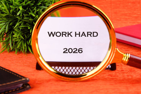A motivational text stating WORK HARD is viewed through a magnifying glass, with the year 2026 below...