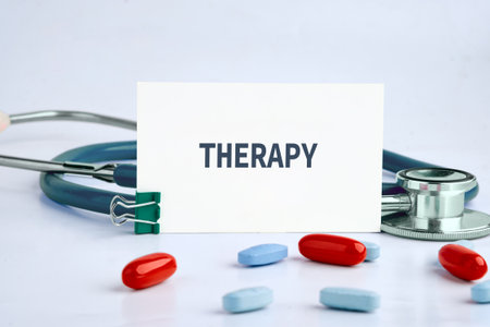 A stethoscope, pills, and a card with the word Therapy suggest medical treatment and care. The scene implies health, well-being, and support for recovery.の写真素材