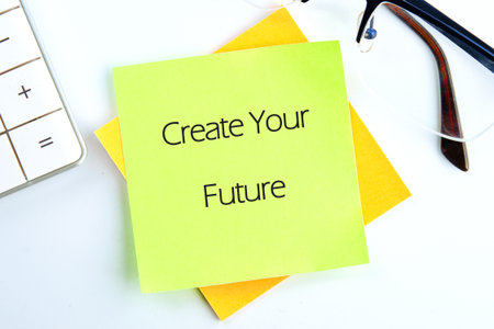 Notes that say Create Your Future are on a bright desk, accompanied by a white calculator and...