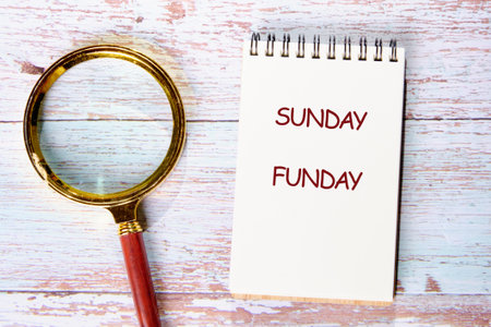 A Sunday cozy Funday scene features a notebook with emphasis on fun, surrounded by a magnifying glass, inviting creativity and exploration with friends and family.の写真素材