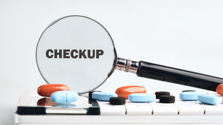 A magnifying glass highlights the word checkup on a table scattered with various colorful pills.の写真素材