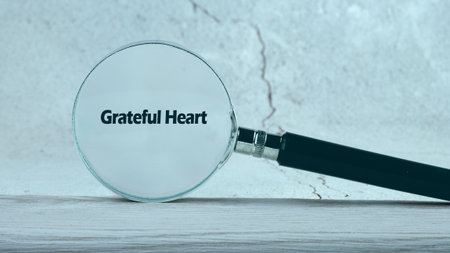 A magnifying glass focuses on the words Grateful Heart, symbolizing the beauty of gratitude and appreciation. This moment invites reflection and joy in a tranquil setting.の写真素材