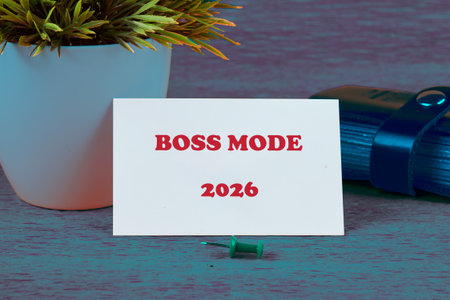 A card reads BOSS MODE 2026 near a desk plant and blue pen. The pin is on the table. Ready to work...