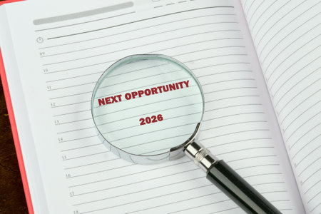 A magnifying glass highlights NEXT OPPORTUNITY 2026 on the right page of an open notebook, which is...