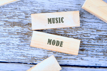 Two light-wood blocks show the words MUSIC and MODE in dark lettering. Other blocks are nearby, all...
