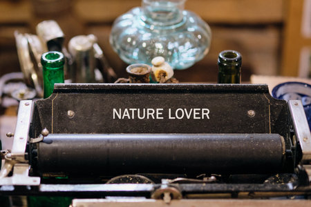 A vintage typewriter with the words Nature Lover is showcased. Glass bottles and old objects sit...