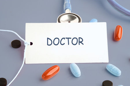 A stethoscope rests besides various colored pills and a label reading doctor, highlighting the importance of healthcare professionals. This scene captures the essence of medical practice.の写真素材