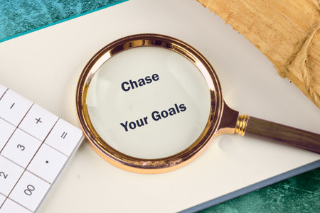 A motivational scene featuring a magnifying glass over a notebook with the phrase Chase Your Goals...