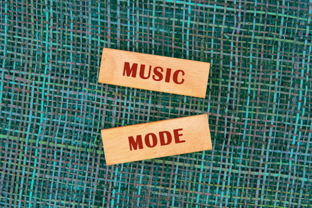 Two wooden blocks display the words music and mode against a colorful textured background, inviting creativity and fun in musical exploration and artistic expression.の写真素材