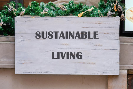 A wooden sign displaying the words sustainable living stands out against a backdrop of greenery. This community space invites people to engage in eco-friendly activities and ideas.の写真素材