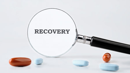 A magnifying glass focuses on the word RECOVERY, surrounded by several prescription pills on a white surface, symbolizing health and medical care.の写真素材