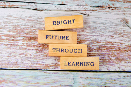 Wooden blocks spell out a motivational phrase about education. Set on a rustic surface, this scene emphasizes growth, hope, and the importance of lifelong learningの写真素材