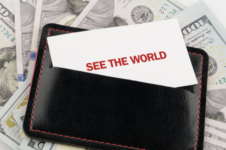A wallet holds a card suggesting exploration and adventure, surrounded by crisp dollar bills, capturing the spirit of travel and excitement waiting to be embraced.の写真素材
