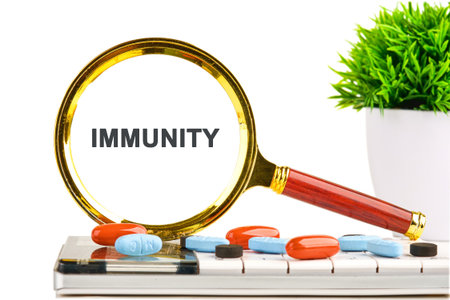 A magnifying glass highlights the word immunity on a tablet, surrounded by colorful pills and a lively green plant, symbolizing health and the quest for knowledge in medicine.の写真素材