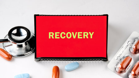 Colorful sign displaying the word recovery is set next to a stethoscope and various capsules, symbolizing hope and healing in a medical context.の写真素材