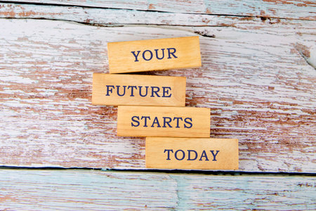 Four wood blocks are stacked on a rustic white surface with the inspiring phrase YOUR FUTURE STARTS...