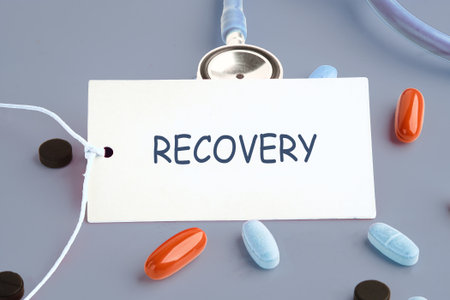 A medical display features a card with the word Recovery, along with colorful pills and a stethoscope, representing the path to health and wellness.の写真素材