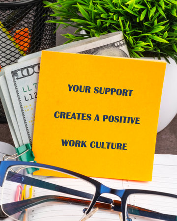 A vibrant yellow sticky note prominently displays a powerful message encouraging a positive work...