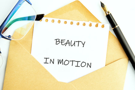A profound message BEAUTY IN MOTION unfolds on a white sheet from a brown envelope.