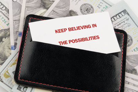 A white card shows Keep believing in the possibilities in red capital letters, placed in a black...