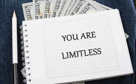 YOU ARE LIMITLESS is clearly written on a grid paper notebook page. A white pencil rests near the spiral binding.の写真素材
