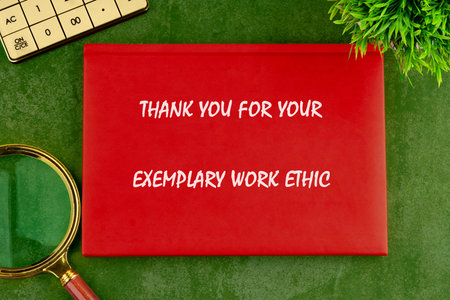 Red gratitude card for great work ethics on green desk with calculator and magnifying glass.