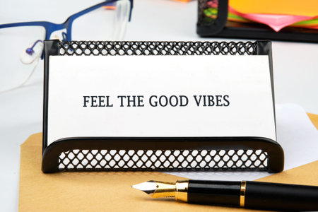 Feel the Good Vibes card holder, pen, glasses, sticky notes on a neat desk inspire positive work.