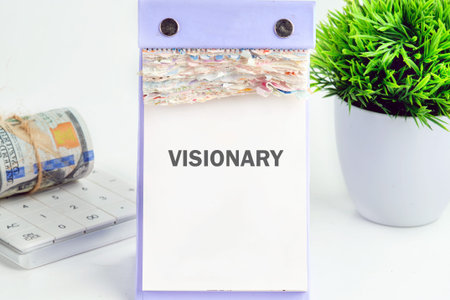 VISIONARY calendar, dollars, calculator, and plant on desk. Symbolizes financial plans and future...