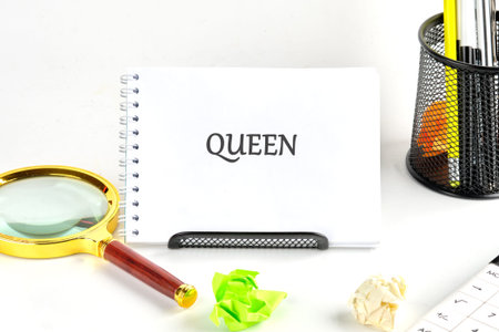 The word QUEEN proudly displayed on a bright notepad, centered on a clean white surfaceの写真素材