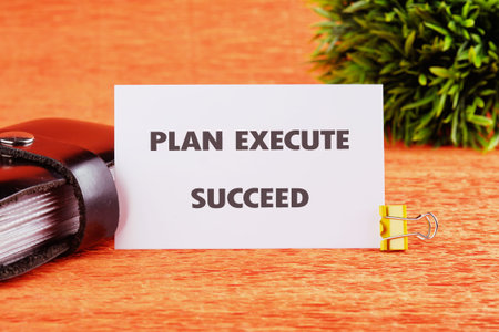 A motivational message boldly displayed on a white card, held by a golden clip, rests beside a dark...