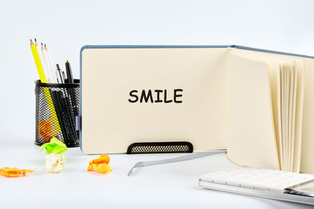 An open blue journal reveals the cheerful word SMILE. A mesh pen holder holds writing tools, while...