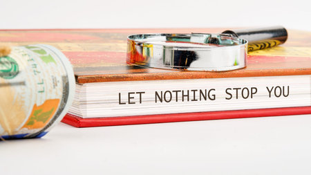 A powerful message of motivation rests on an open book, accompanied by a magnifying glass and a...