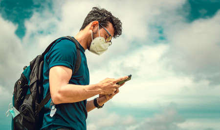 Adventurous man in the field with phone, man with backpack in the field chatting
