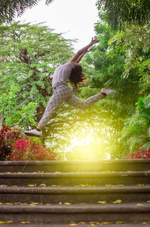 Girl jumping surrounded by trees, concept of happy girl jumpingの写真素材