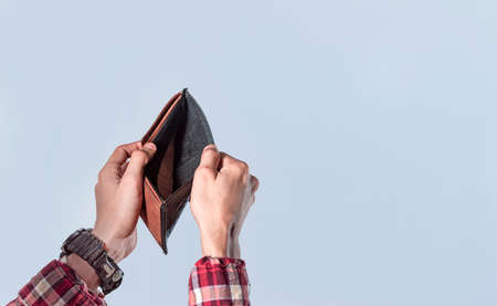 Concept of an empty wallet, hand opening empty wallet on isolated background, concept of economic...