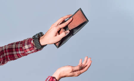 Concept of an empty wallet, hand opening empty wallet on isolated background, concept of economic crisisの写真素材