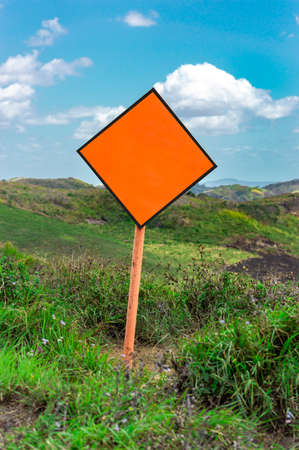 An empty sign on top of a hill, empty sign surrounded by vegetationの写真素材
