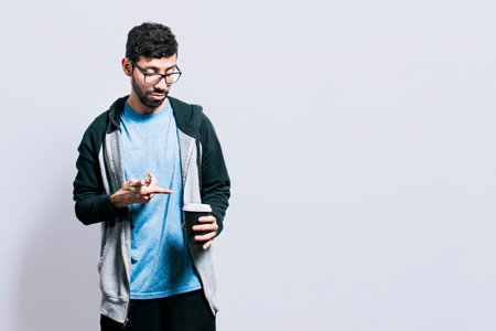 Person with coffee on isolated background, guy pointing disposable cup of coffee on isolated...
