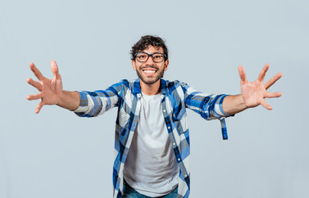 Man welcoming with open arms isolated. Friendly person welcoming. Generous young man with open arms isolated, Man sharing with open hands looking at the camera with a friendly smileの写真素材