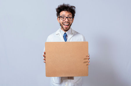 A scientist in a white coat is holding and showing a blank clipboard. Scientist showing and pointing...