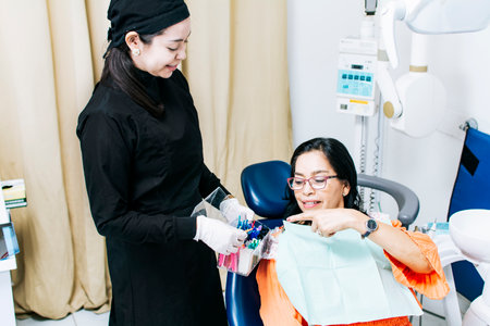 Patient with dentist choosing dental braces, Dentist with patient choosing metal braces, Patient with dentist choosing rubber bandの写真素材