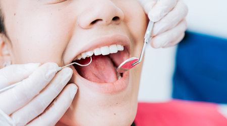 Hands of a specialist dentist cleaning the teeth of a female patient. Close up of dentist hands...