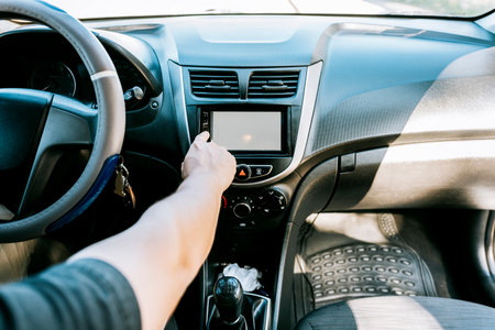 Close up of driver tuning into the radio station. Distracted driver concept tuning the radio. Hand...