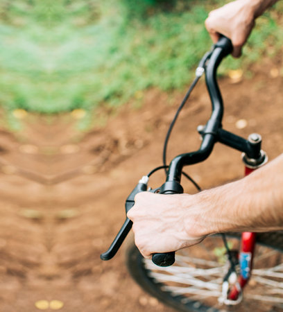 High angle of hands on bicycle handlebars, Side view of hands on bicycle handlebars. Concept of cyclist's hands on the handlebarsの写真素材