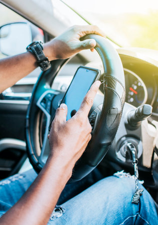 Close up of driver hands using his phone, Concept driver hands touching cell phone screen, Person in...