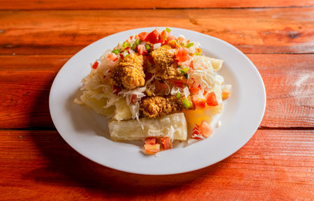 Traditional chicharron dish with cassava and tomato salad. Latin food chicharron con yuca served on...